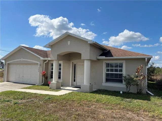 View of front of home featuring a garage and a front lawn