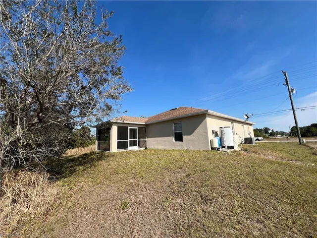 Rear view of house with a lawn and a lanai