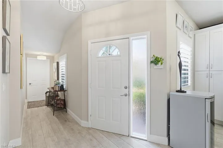 HALL TO ATTACHED GARAGE AND SPACIOUS STORAGE CLOSET...PLANK TILE FLOORING THROUGHOUT HOME..