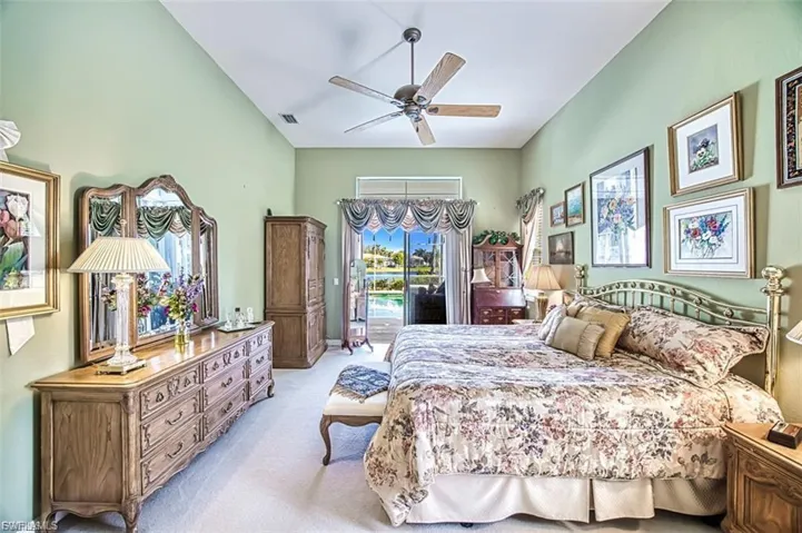 Bedroom featuring access to exterior, light carpet, ceiling fan, and vaulted ceiling