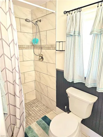 Bathroom with toilet and curtained shower