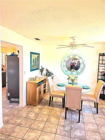 Tiled dining room with ceiling fan and a textured ceiling