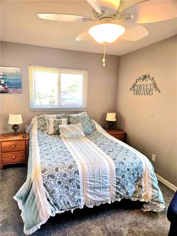Carpeted bedroom featuring ceiling fan