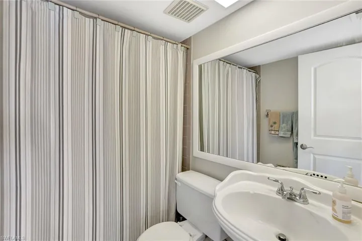 Bathroom featuring sink, toilet, and a shower with curtain