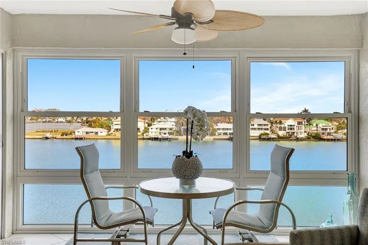 Sunroom featuring ceiling fan and a water view