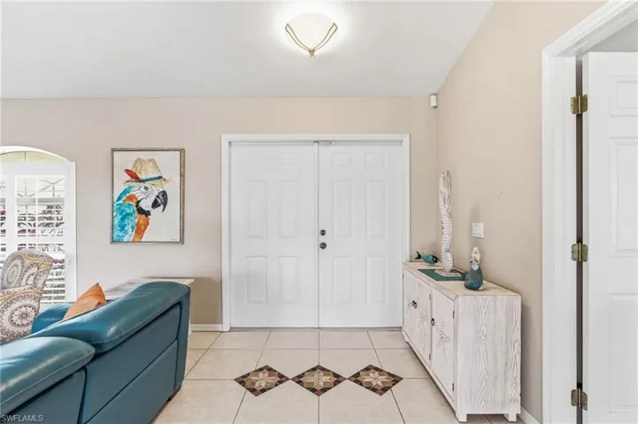 The property features neutral-toned walls, tile flooring with decorative accents, and a double entry door