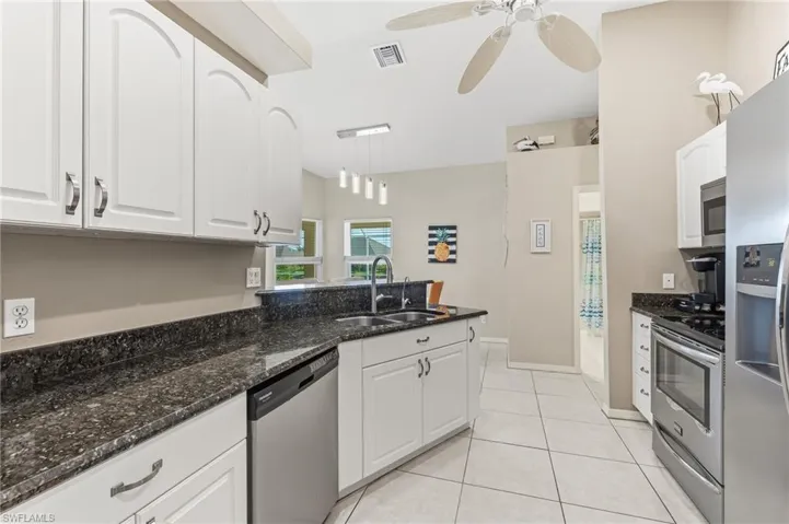 Granite counter-tops, ss appliances, white raised cabinets.