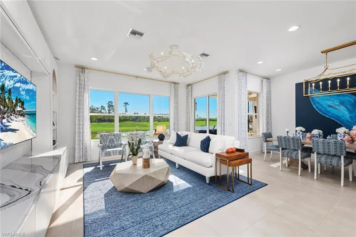 Living room with light tile patterned floors, a notable chandelier, visible vents, and recessed lighting