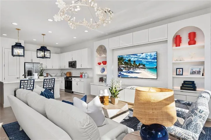 Living area with recessed lighting, built in shelves, and a notable chandelier