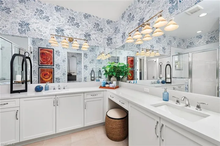 Bathroom featuring a shower stall, tile patterned floors, wallpapered walls, vanity, and visible vents