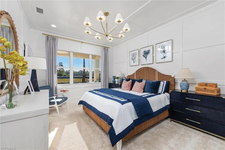 Bedroom featuring visible vents, ornamental molding, light carpet, and an inviting chandelier