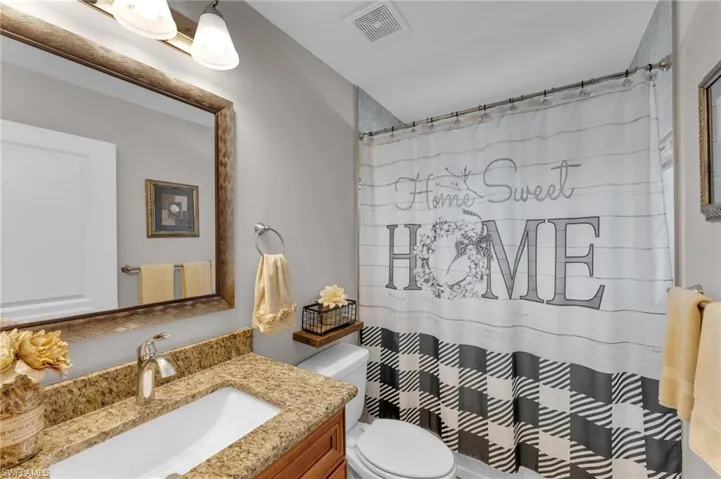 Full bathroom with curtained shower and vanity