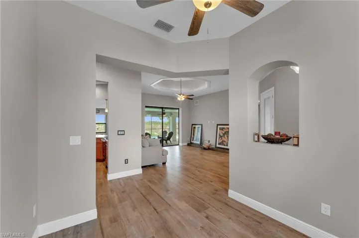 Hall featuring light wood-style flooring and a raised ceiling