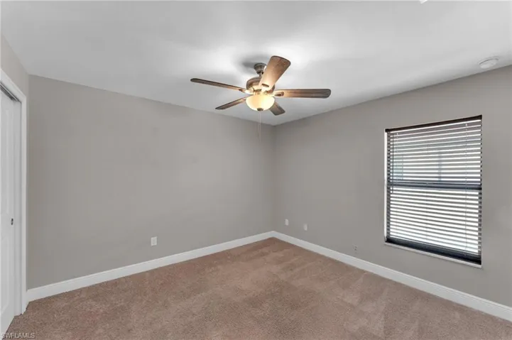 Unfurnished room with light carpet and ceiling fan