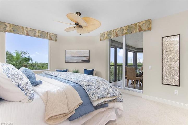 Primary bedroom with tropical views from window and adjacent lanai
