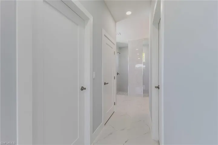 Hall featuring recessed lighting and light marble finish floors