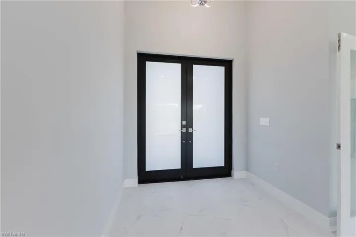 Foyer featuring french doors and light marble finish floors