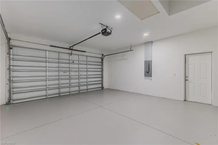Garage featuring electric panel and a garage door opener