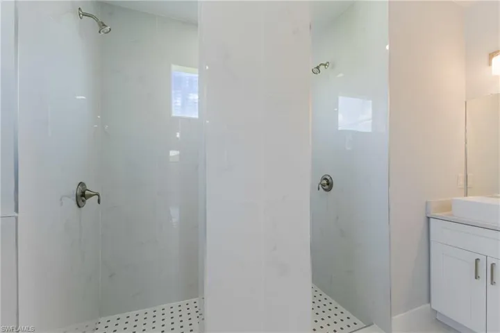 Full bath with vanity and a marble finish shower
