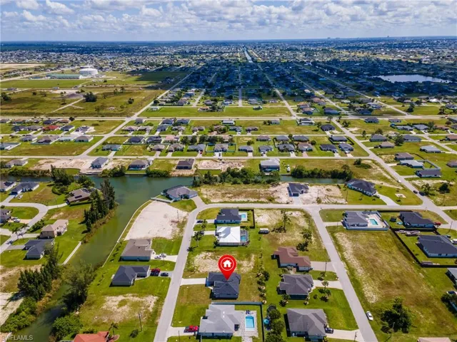 Aerial view of property and surrounding area featuring nearby suburban area and a nearby body of water