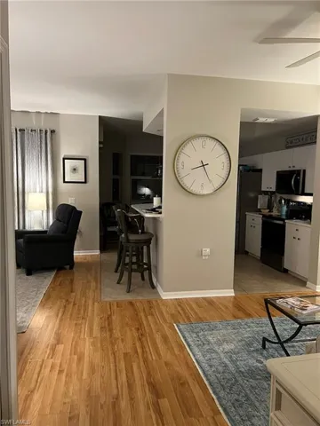 Living room featuring ceiling fan and light hardwood / wood-style flooring