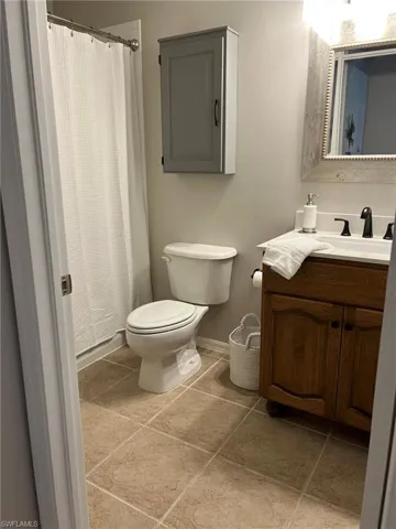 Bathroom featuring tile floors, vanity, and toilet