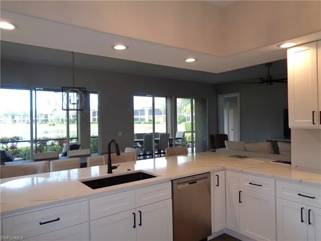 Kitchen featuring white cabinets, stainless steel dishwasher, recessed lighting, and light stone countertops