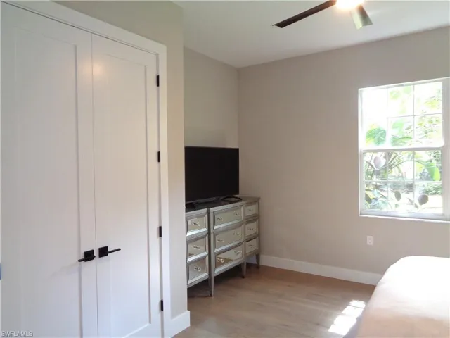 Bedroom featuring light wood finished floors, ceiling fan, and a closet