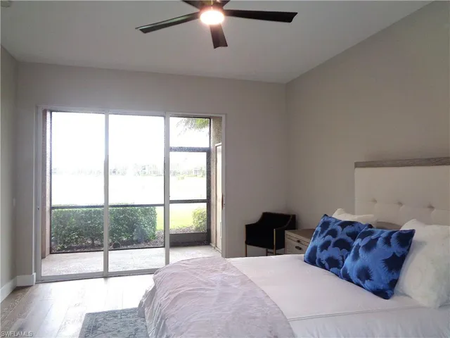 Bedroom featuring a water view, light wood-type flooring, access to outside, and a ceiling fan