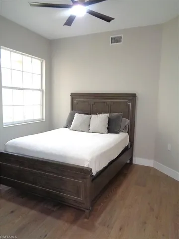 Bedroom featuring dark wood-style floors and a ceiling fan