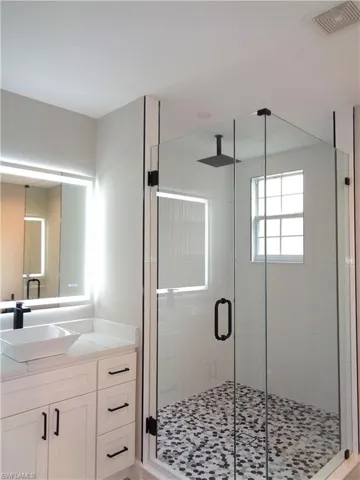 Bathroom featuring vanity and a shower stall