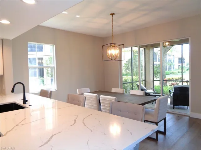 Dining space featuring dark wood-type flooring and hanging lights