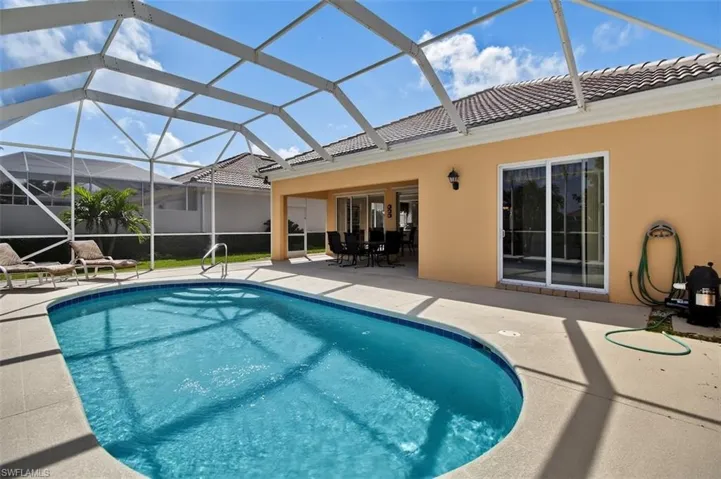 Fully screened-in outdoor pool with outdoor dining space, a patio area, a sunroom, and