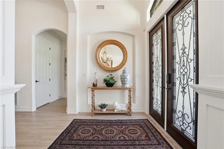 Foyer with wood finish floors and arched walkways