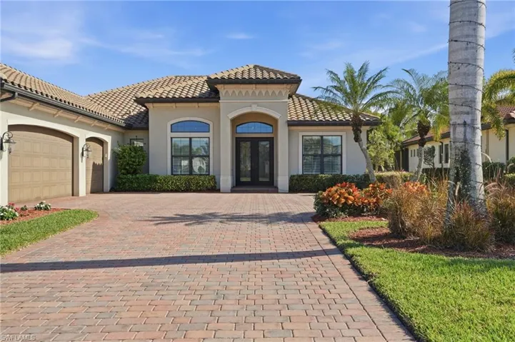 View of front of house with an attached garage, decorative driveway, french doors, and stucco siding