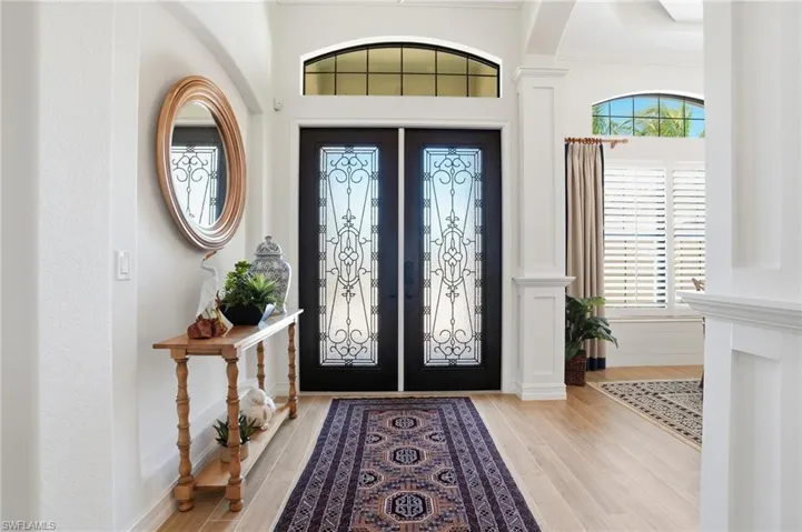 Entryway with french doors, light wood-style flooring, and arched walkways
