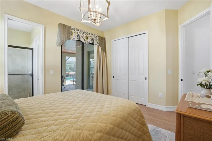 Bedroom featuring light wood finished floors, a closet, and a chandelier