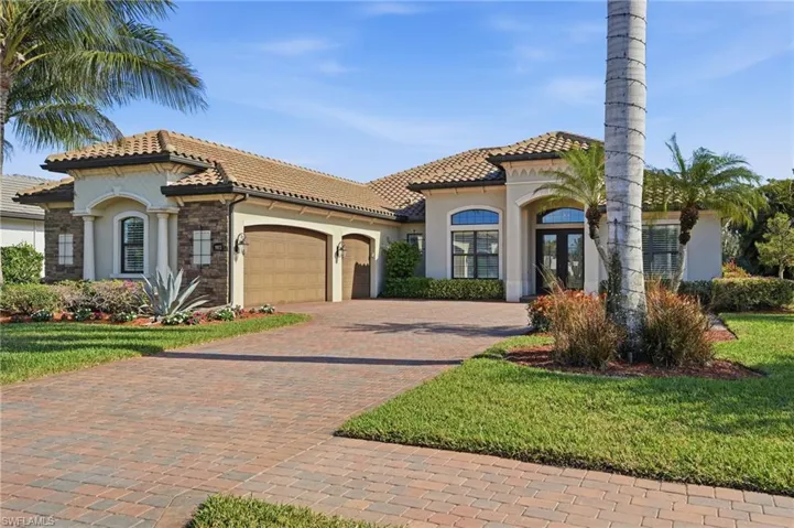 Mediterranean / spanish house featuring stucco siding, a garage, decorative driveway, and a tiled roof