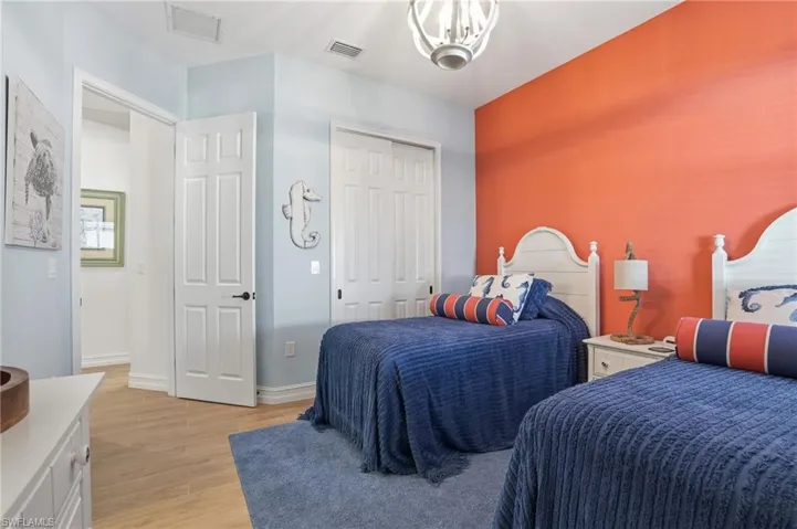 Bedroom featuring light wood-type flooring, a closet, and a chandelier