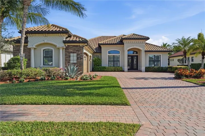 Mediterranean / spanish house featuring french doors, decorative driveway, stucco siding, a garage, and a front yard