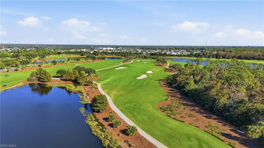 Drone / aerial view of a golf course and a nearby body of water