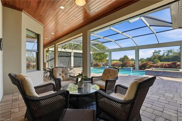 View of patio / terrace featuring a sunroom, a lanai, and a pool with connected hot tub