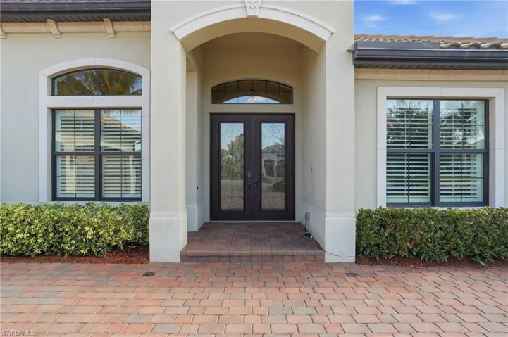 Property entrance featuring stucco siding and french doors