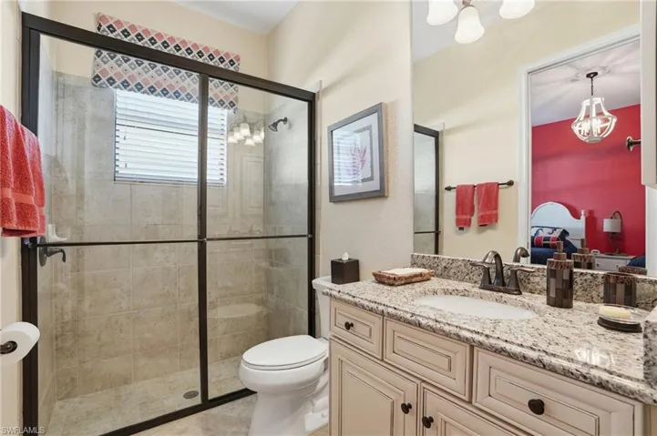 Full bathroom featuring vanity, a chandelier, and a shower stall