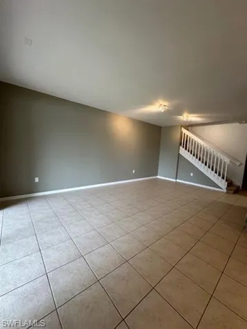 Spare room with stairs and light tile patterned flooring