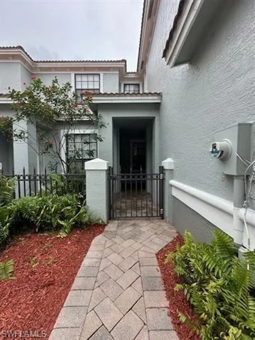 Property entrance featuring a gate and stucco siding