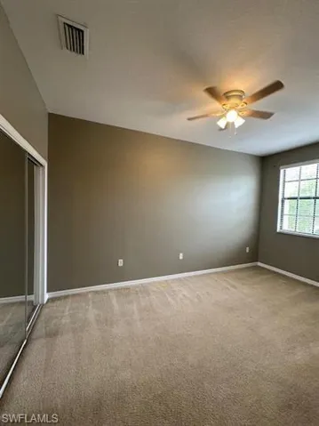Spare room with light colored carpet and a ceiling fan