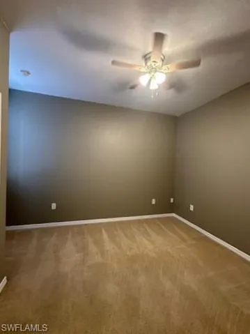 Spare room featuring light colored carpet and ceiling fan