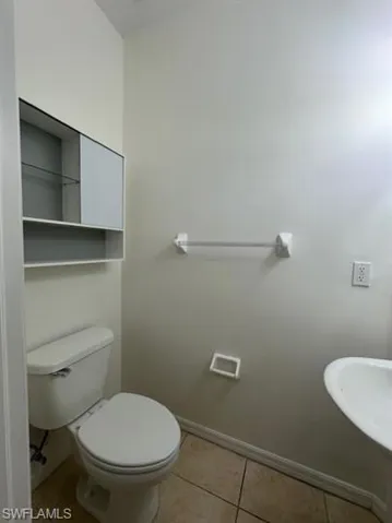 Bathroom with baseboards and light tile patterned floors