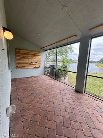 Unfurnished sunroom featuring vaulted ceiling and a water view